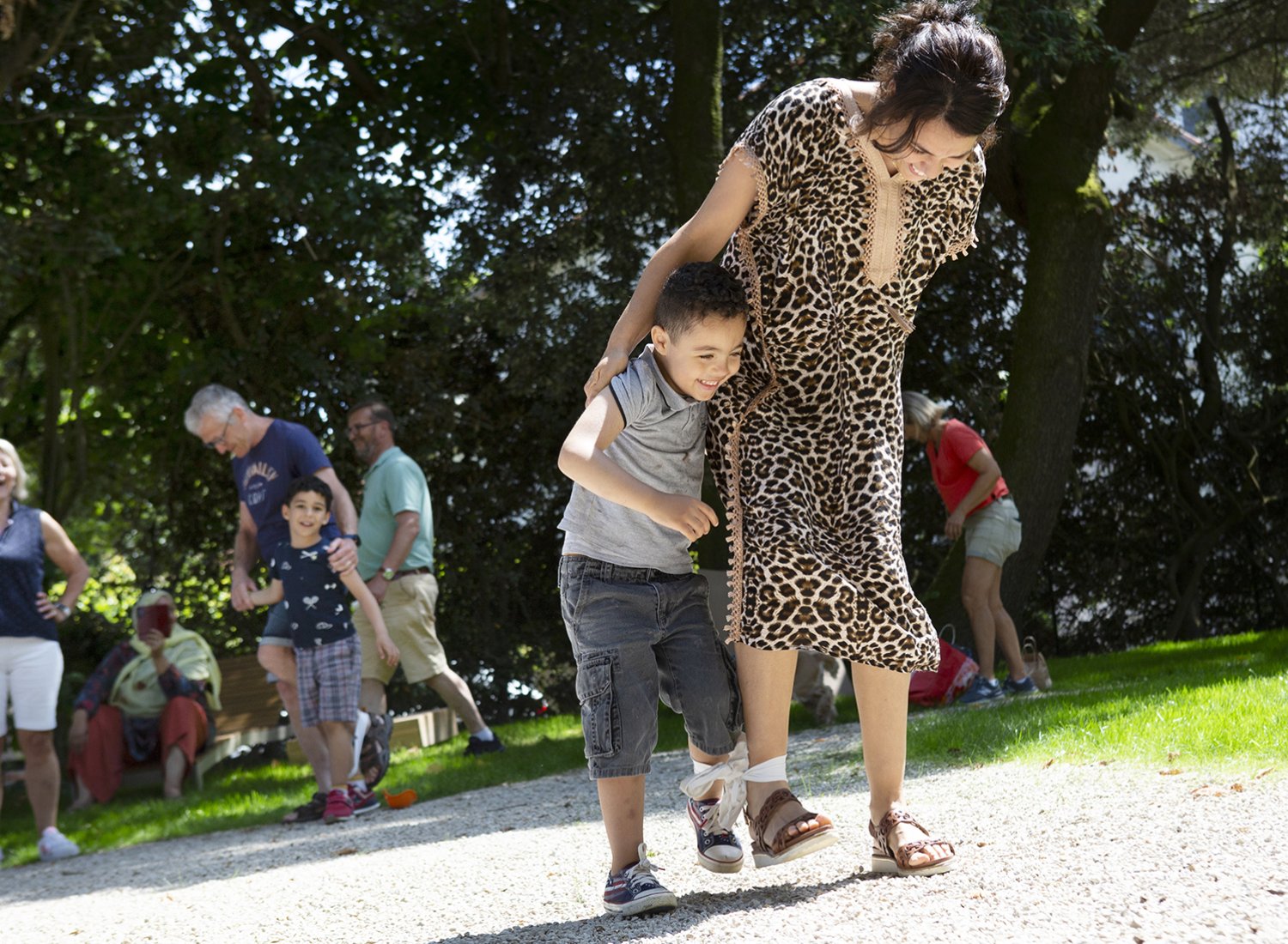 une mère et son jeune fils s'amusent à marcher avec un pied lié à l'autre